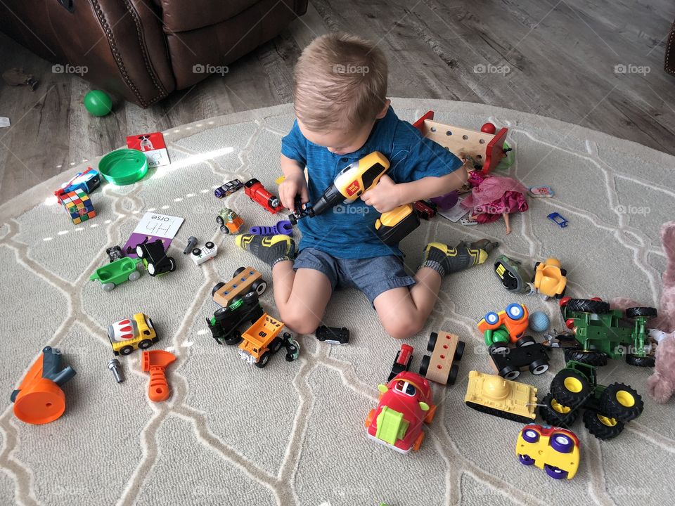 Two year old boy playing with toys 