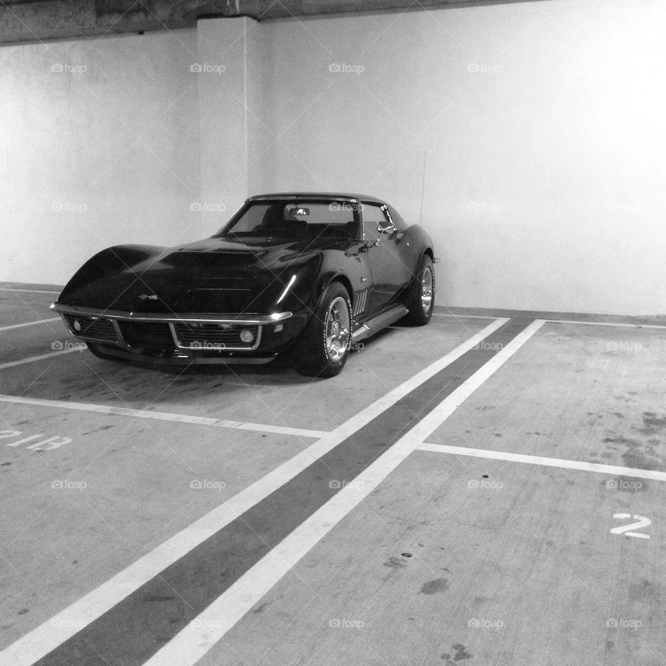 Vintage Corvette parking lot. Parking lot spot occupied by a vintage muscle car chevy corvette