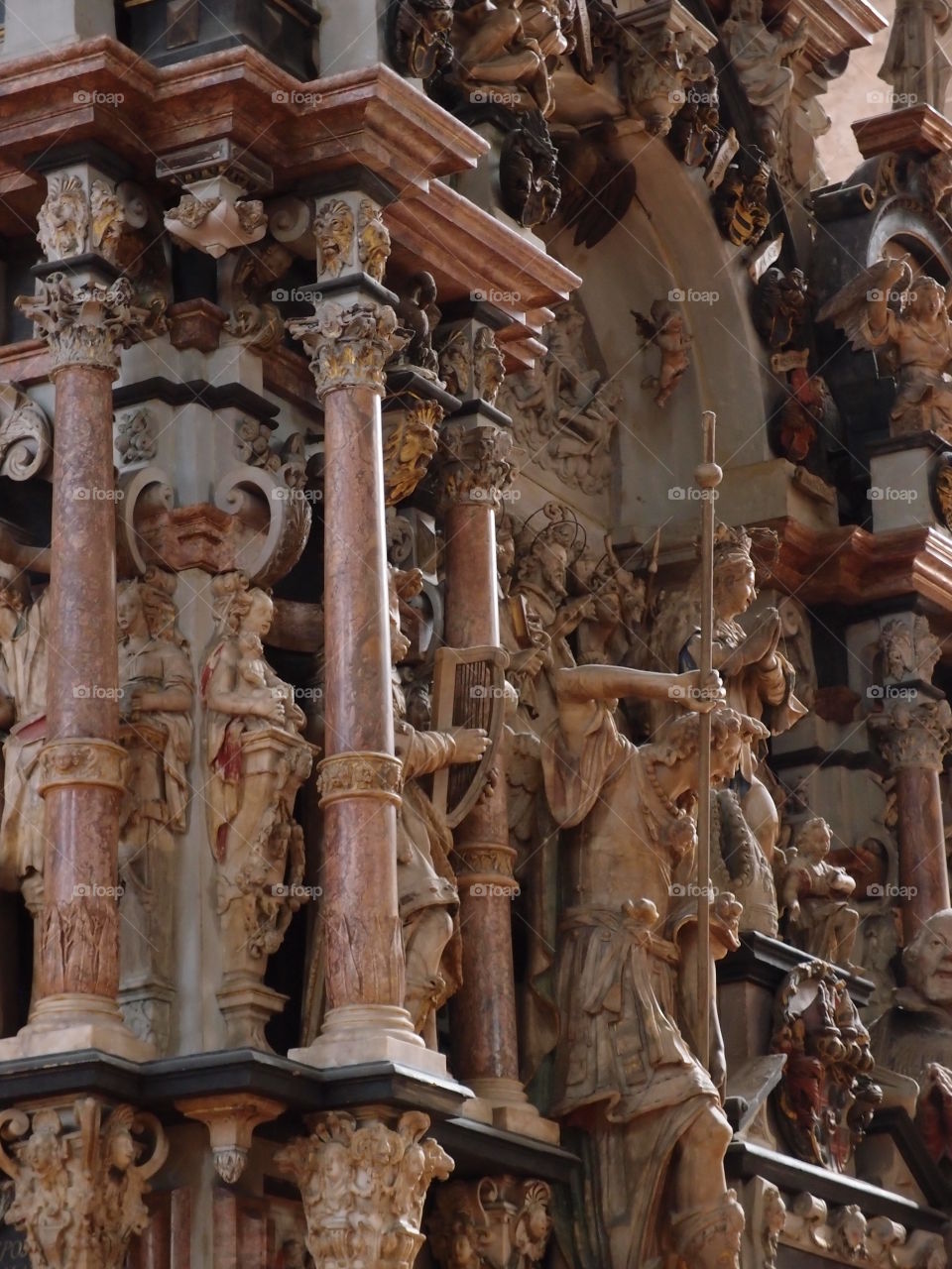 A religious carving in marble depicts figures and pillars in fine detail. 