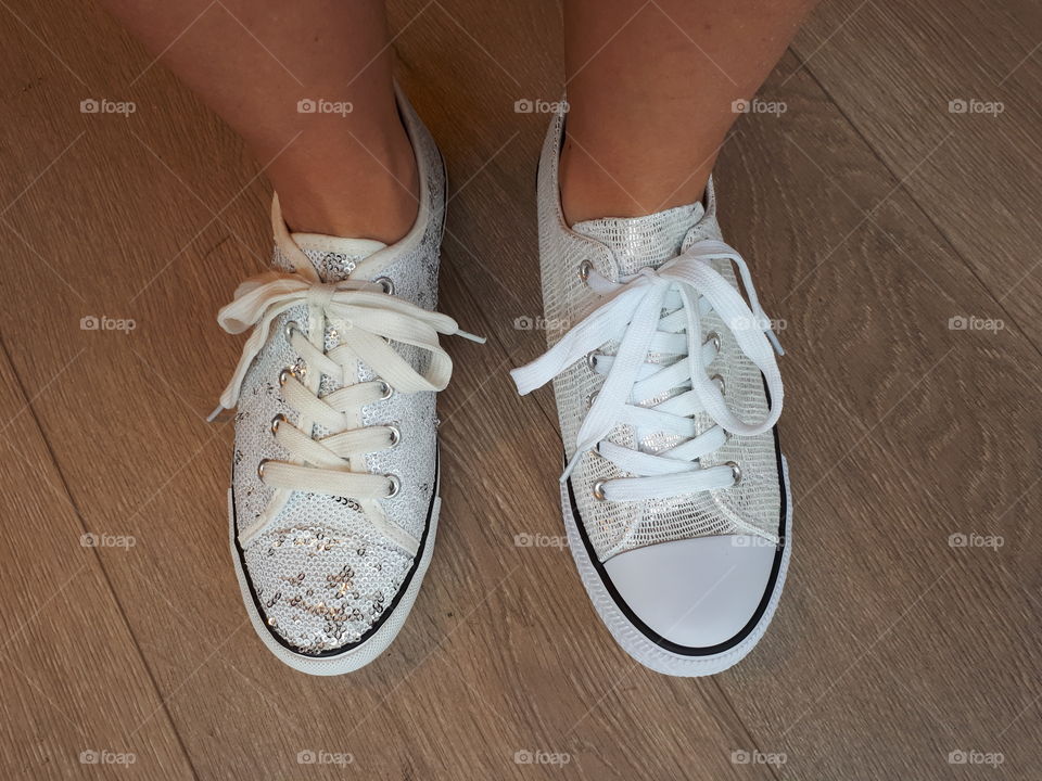 Woman's feet in white different snickers