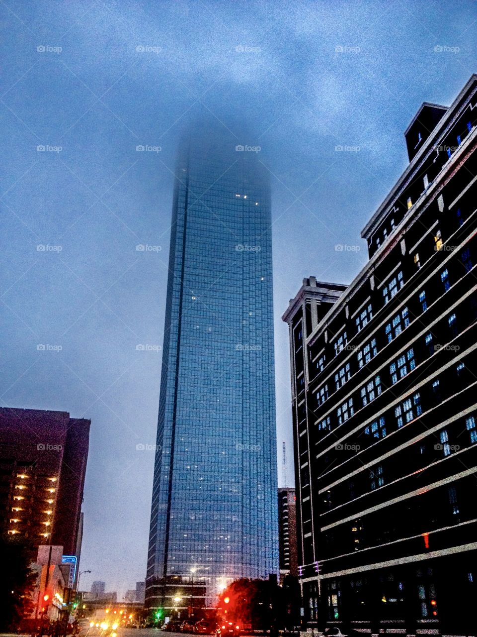 Bank of America Tower shrouded in fog and clouds just past dusk downtown Dallas. 