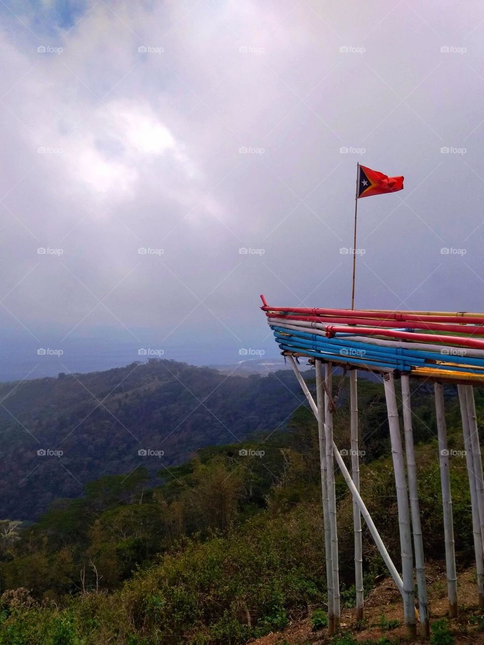 East Timor flag at Gugleur mountain,  on a cloudy day.