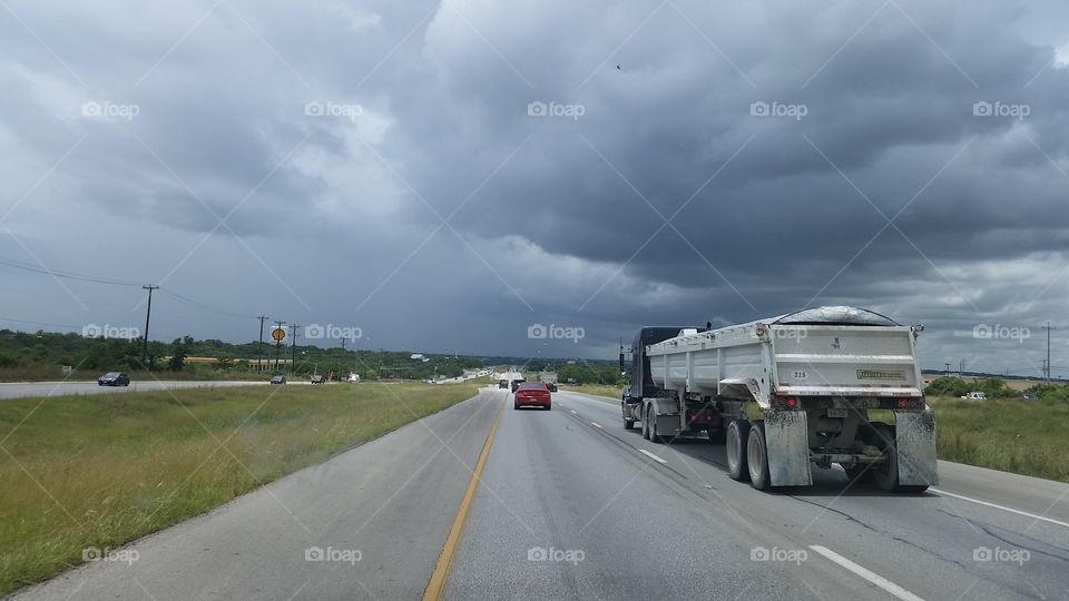 Blue clouds over Texas. Highway traffic with clouds overhead.