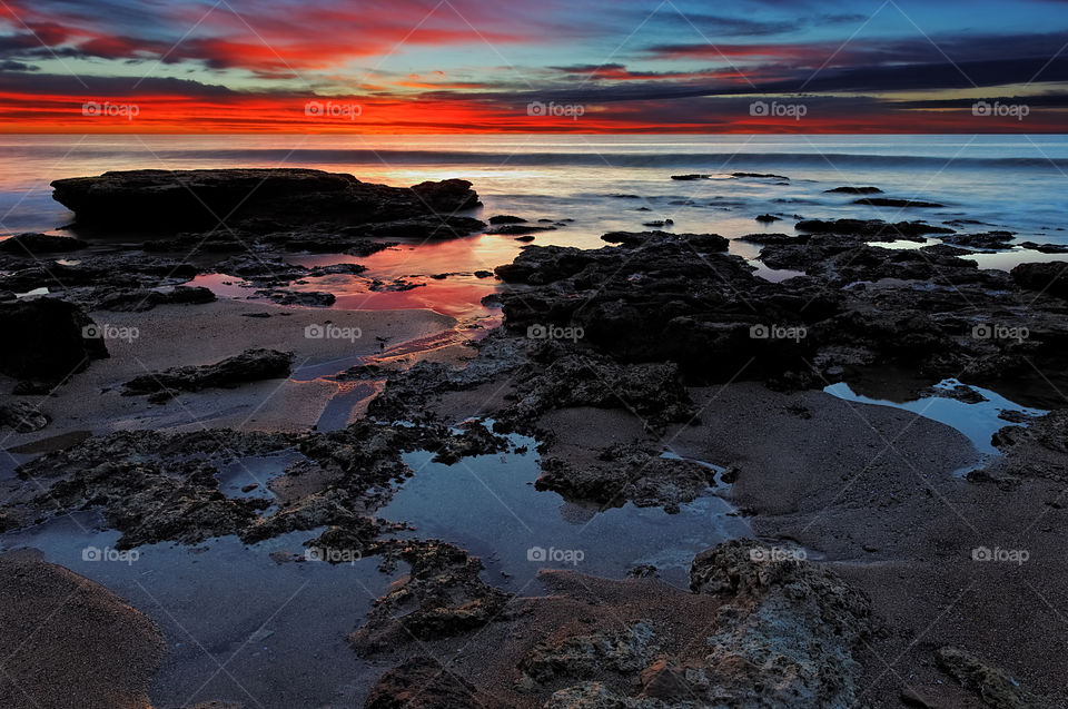 View of rock at beach during sunset