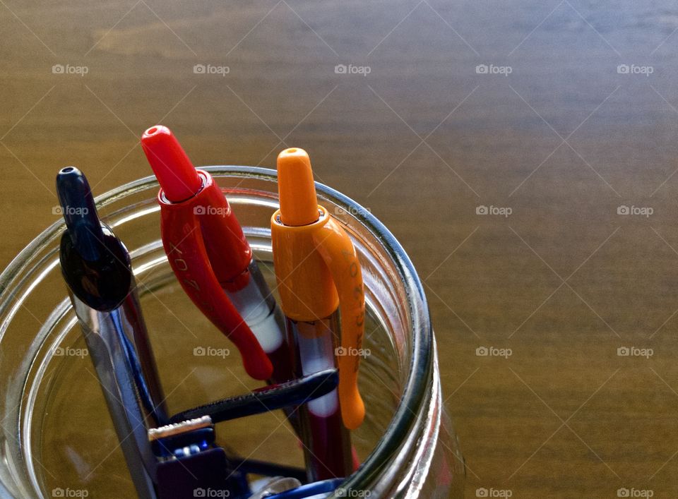 Jar holding pens on wooden drafting table 