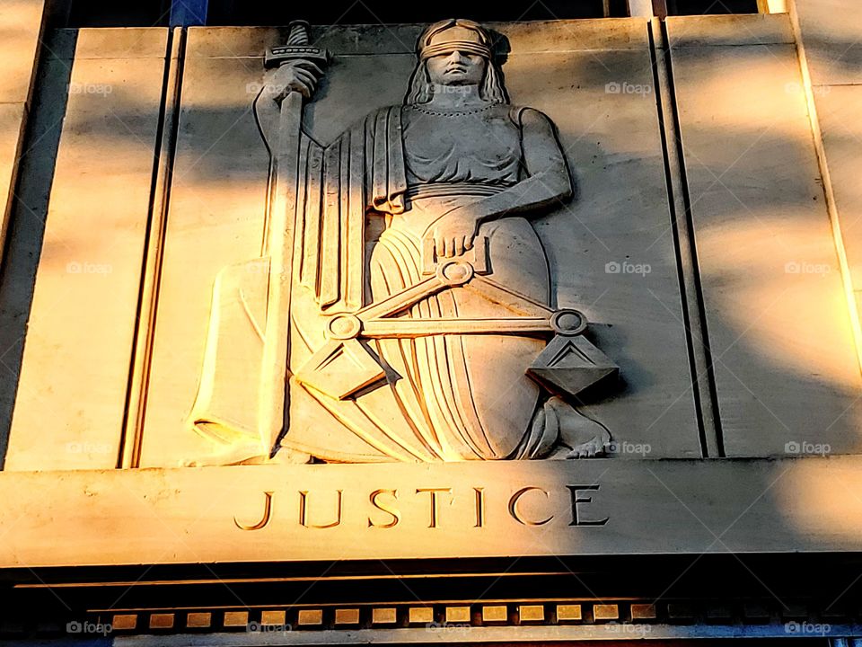 Lady justice stone carving on a courthouse - symbolic of 2019 events