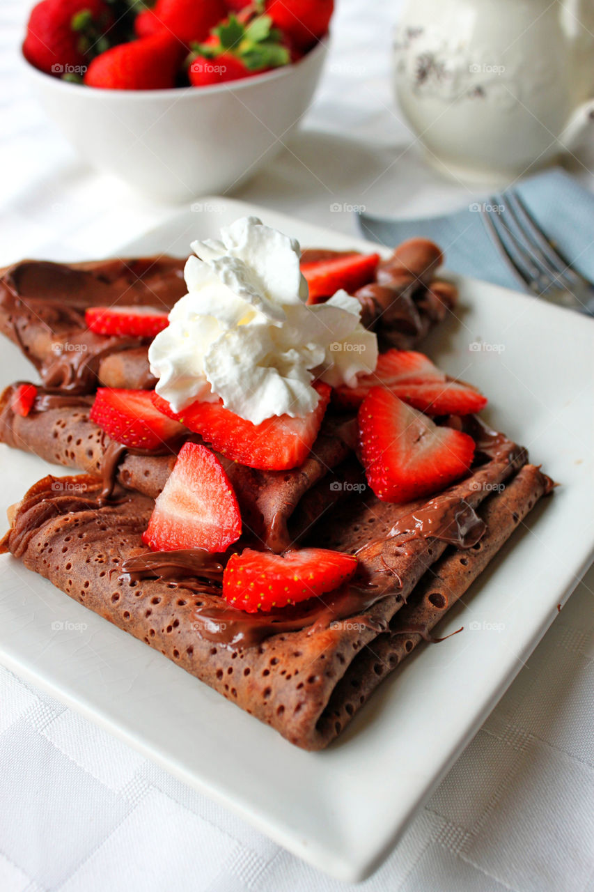 Pancake with chocolate syrup, strawberry and ice cream