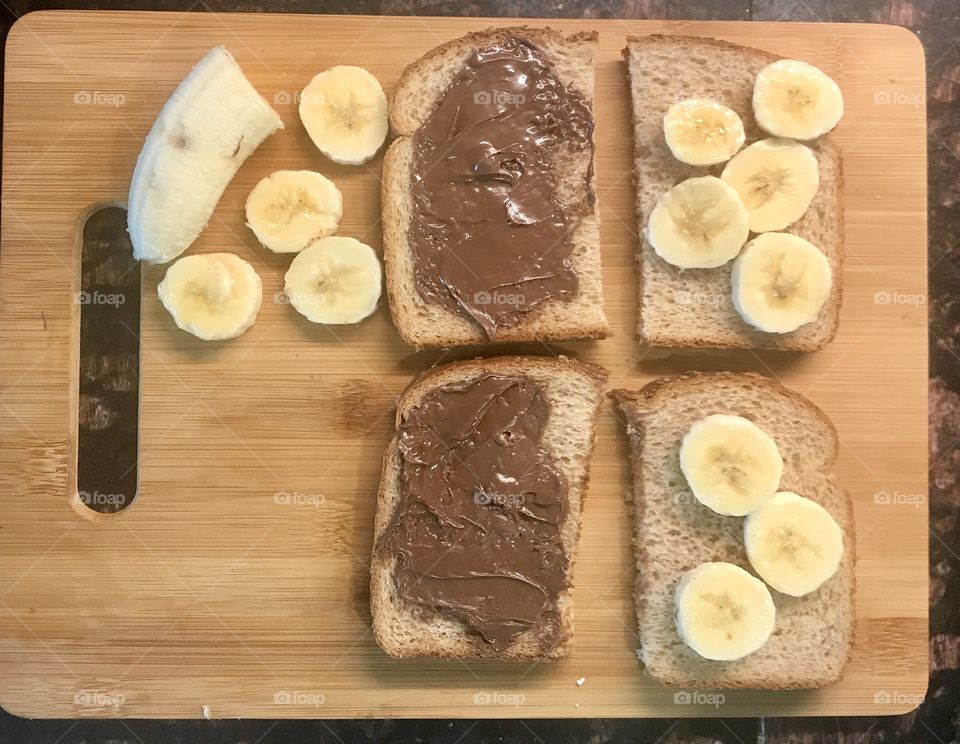 Chocolate Nutella and banana sandwich halves displayed on the wooden cutting board. USA, America 