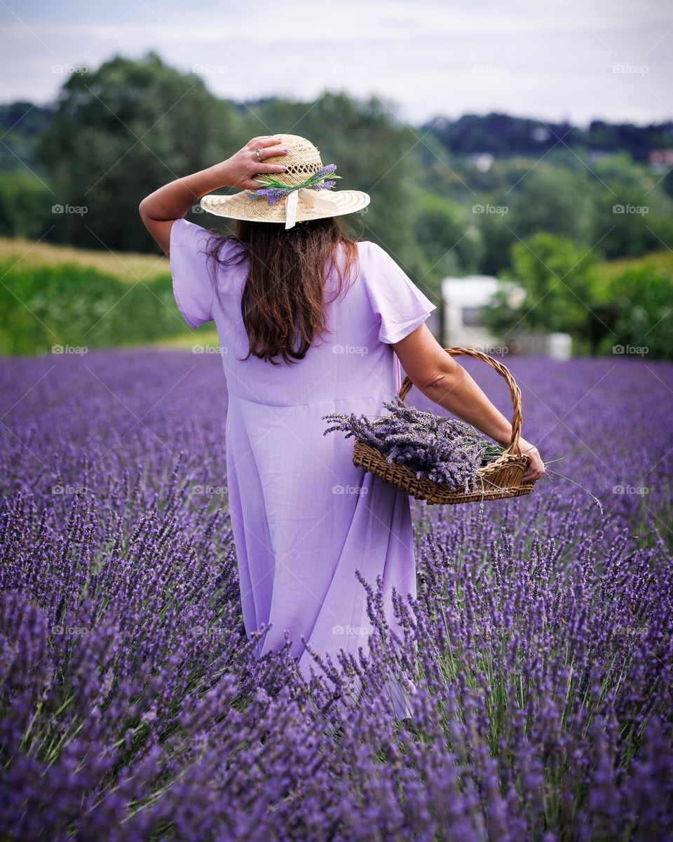 A woman in a purple dress in a lavender field.