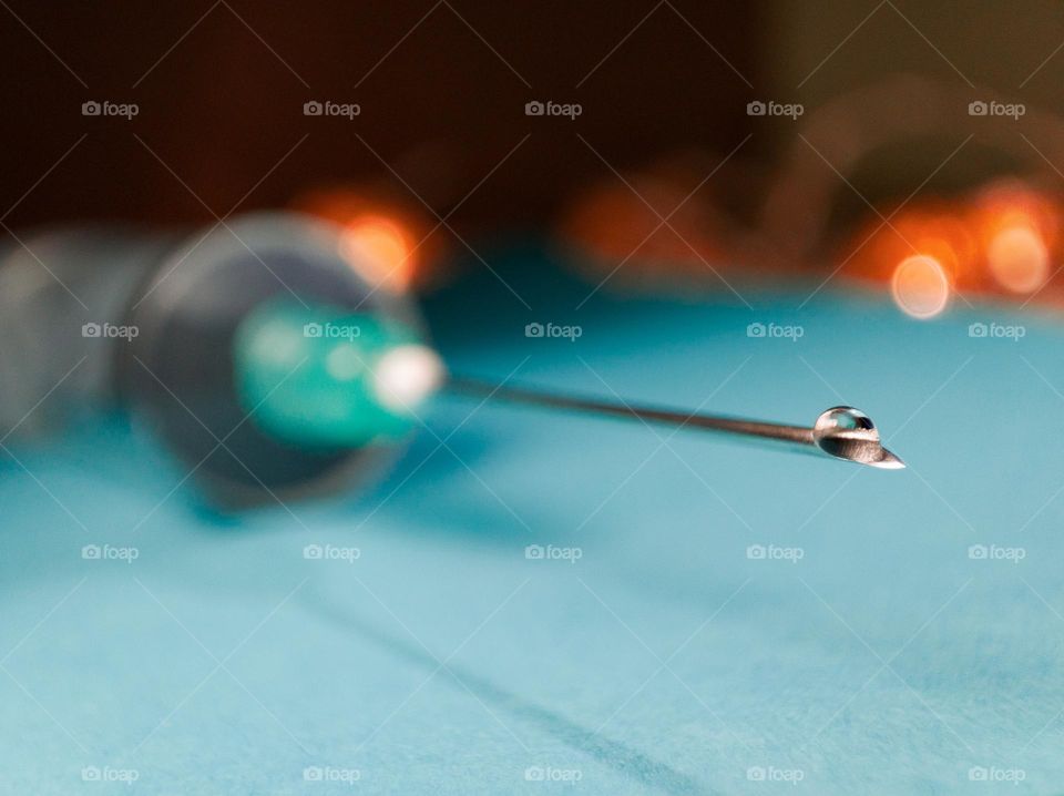 A drop of water on the tip of a needle in a syringe.
