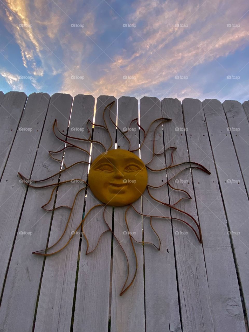 Buddhist sun symbol hanging on a fence in front of the sunset in San Diego California 
