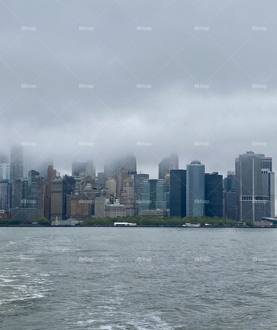 New York City in morning fog from distance over water 