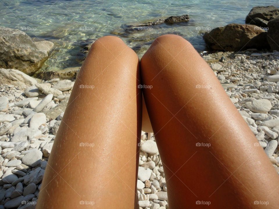 female legs barefoot relaxing on a sea beach summer vacation