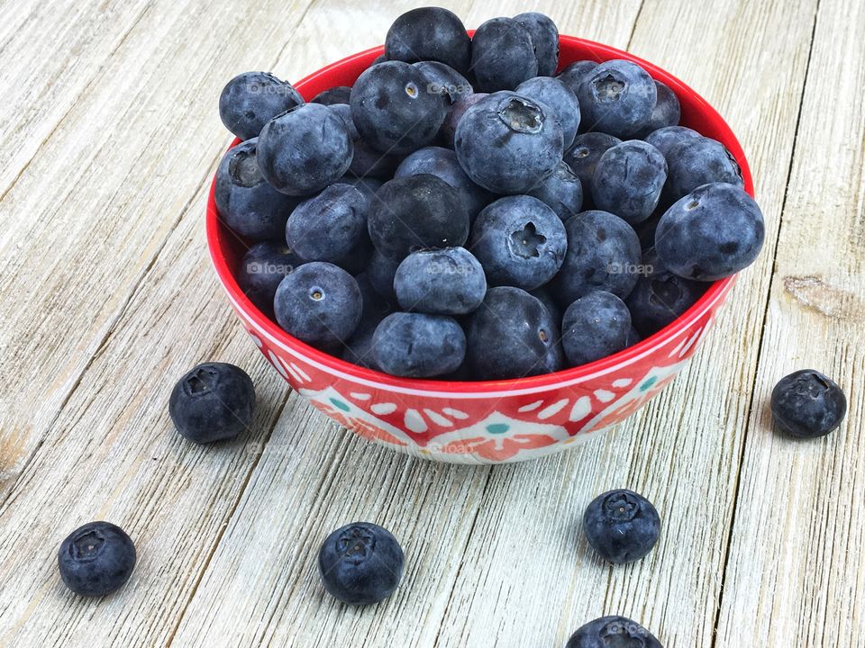 Bowl of Beautiful Blueberries on a White Wood Table