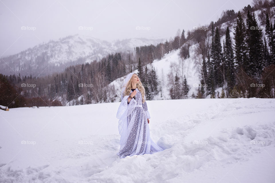 Portrait of woman standing on snowy landscape