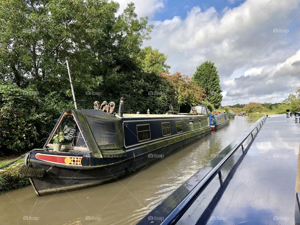 Three wise monkeys on narrowboat moored along oxford canal near Ansty in England cruising with clear sky cool clouds good weather scenery historic waterway