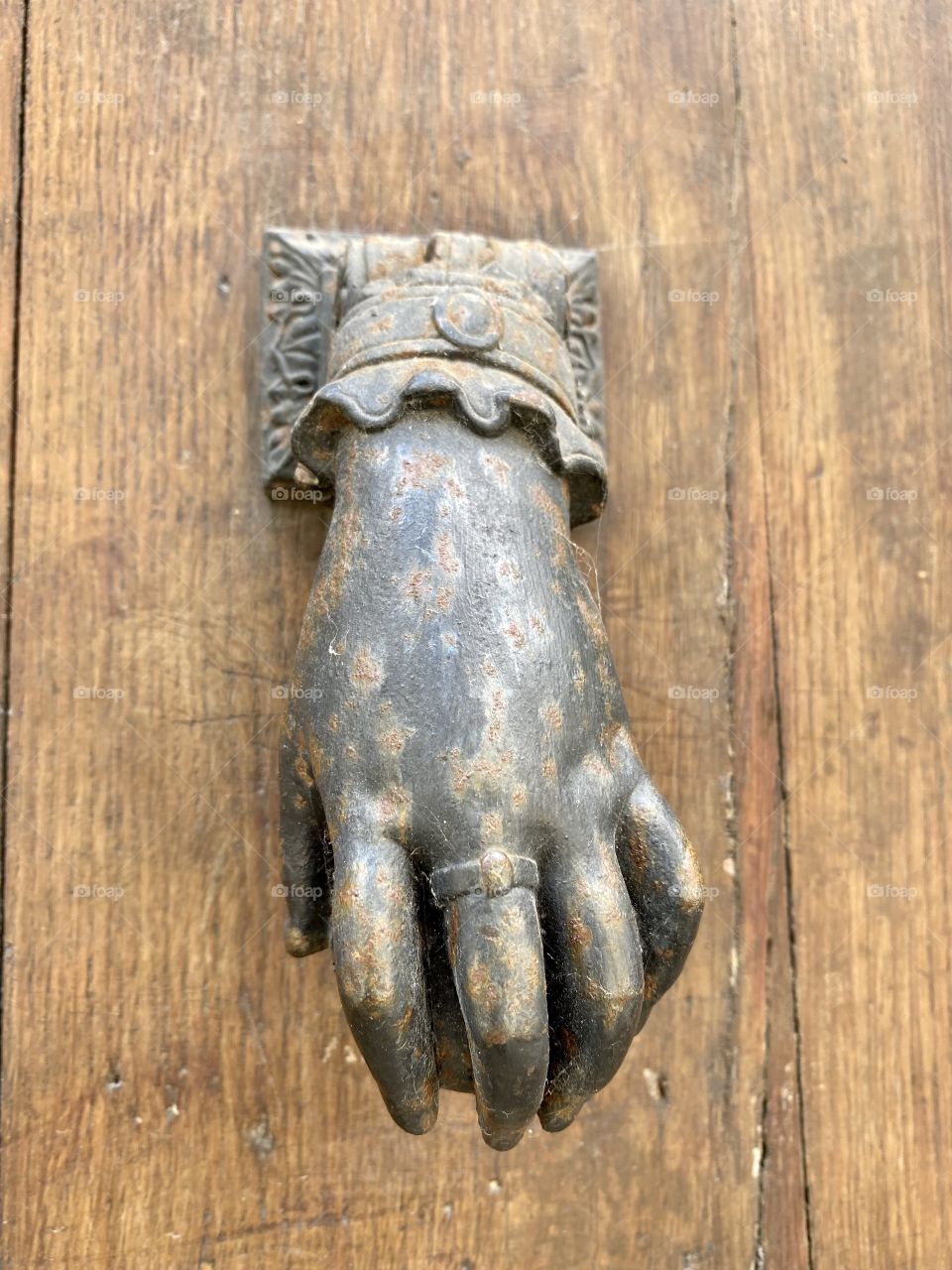 Hand-shaped heurtoir on an old gate of the historic city