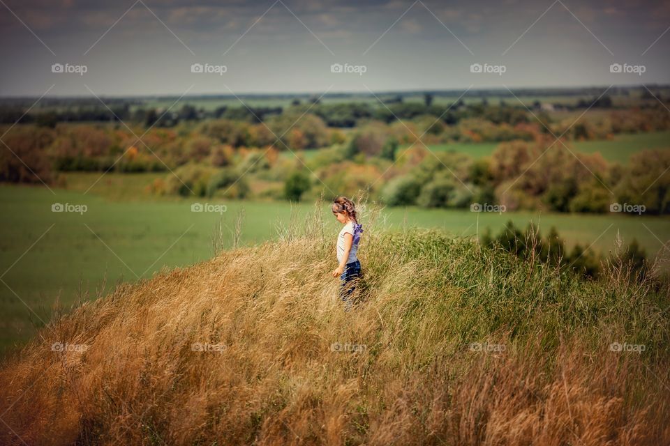 Little girl walking on a hill 