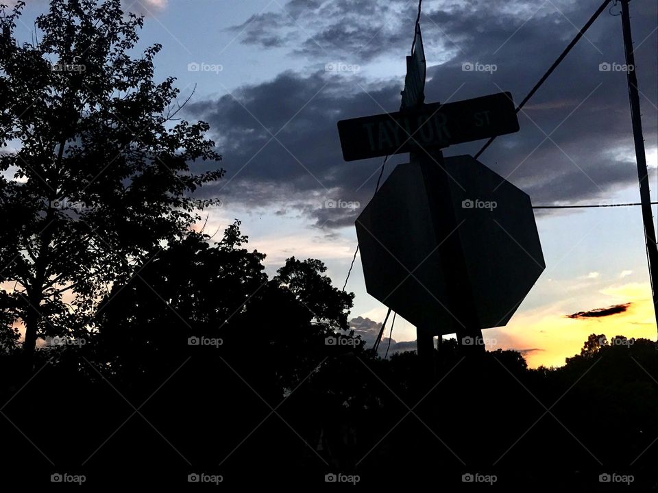 Silhouette view of a stop and street sign with trees. Taken in Thomasville, NC, USA.