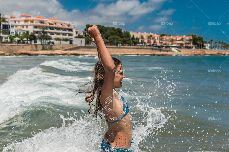 girl is playing and having fun with sea waves