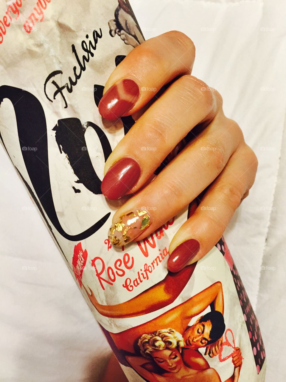 Dusty rose coloured nails with a touch of gold paired with a glass of rosé. 
