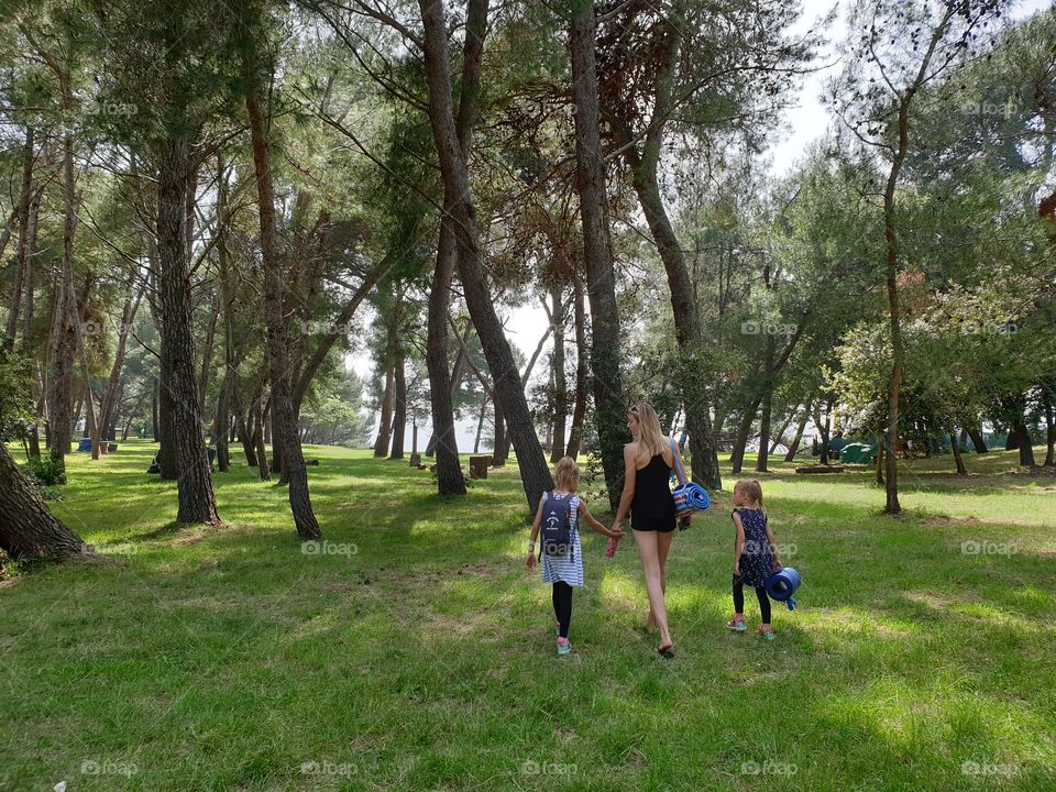 mother and young daughters in a walk in nature.