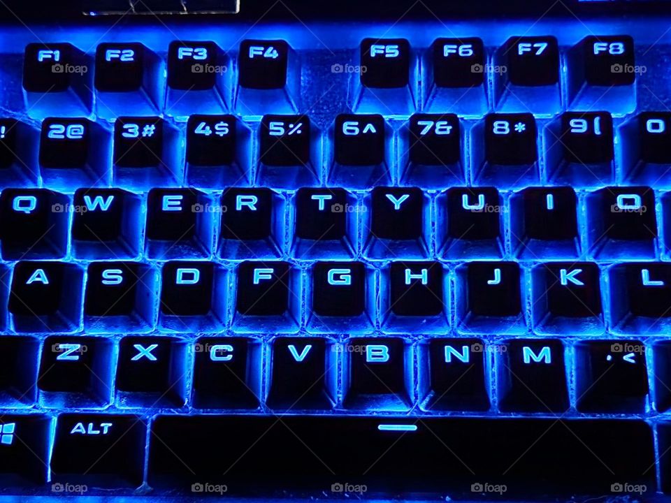 blue back-lit computer keyboard letter keys for night-time communication with friends