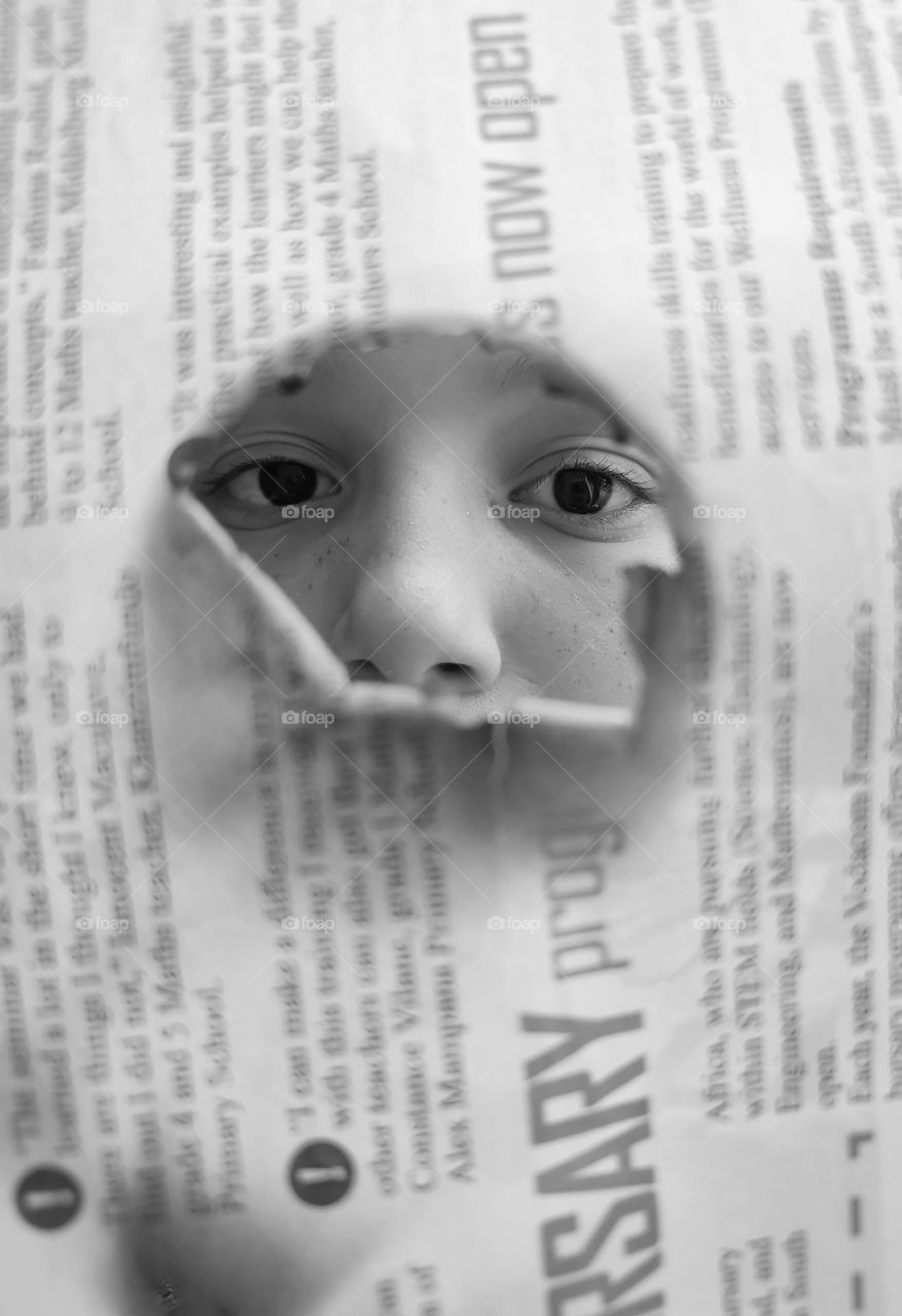 Girl looking through newspaper