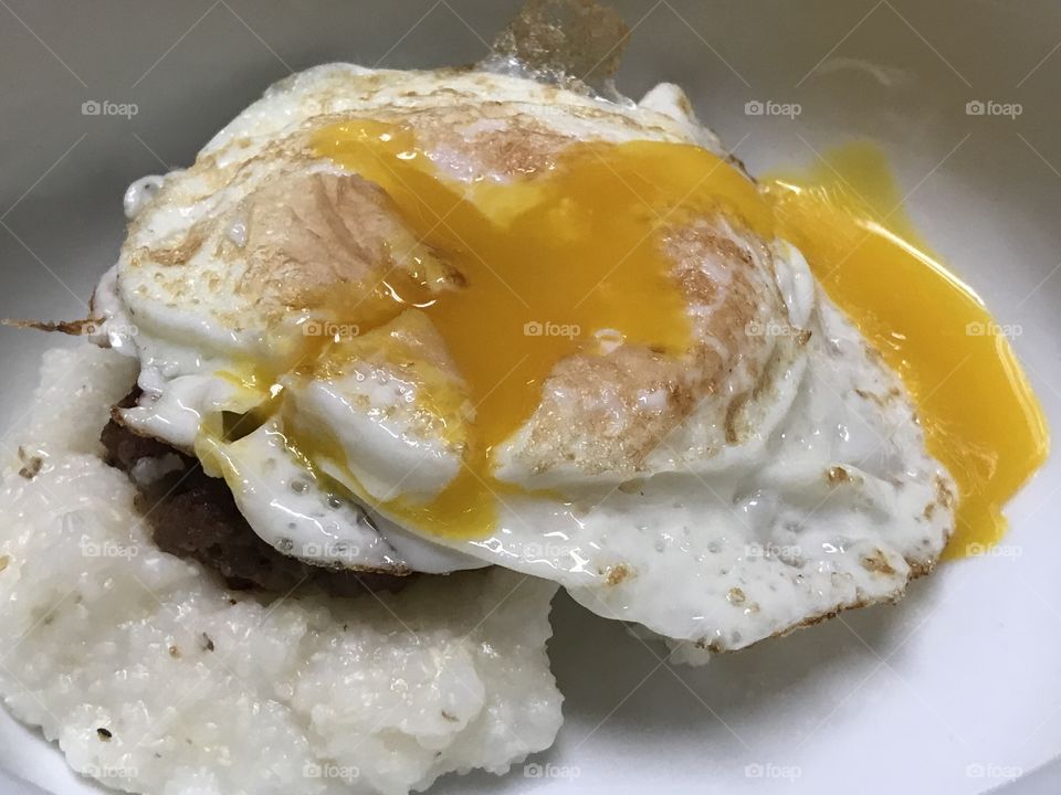 Fried egg on sausage and grits 