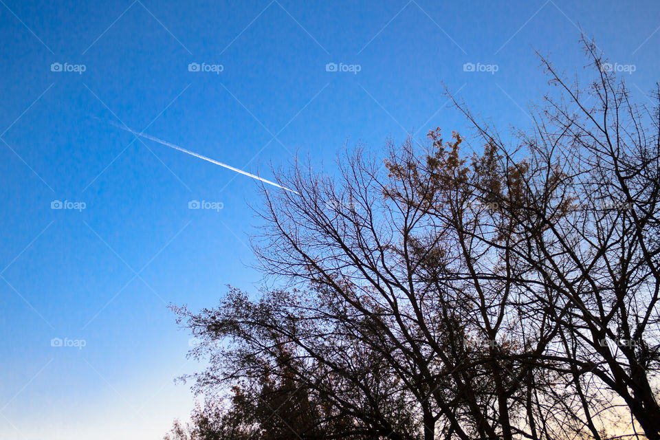 trace of an airplane flying in the blue sky