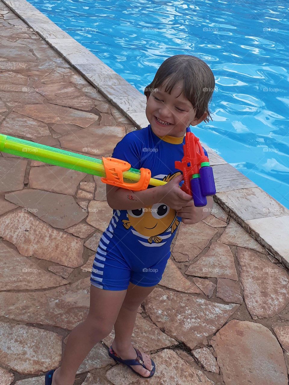 blonde child playing and smiling in the pool