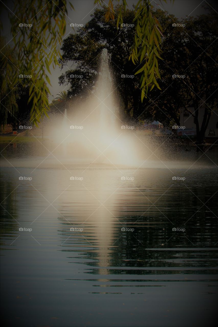 water fountain. A water fountain reflecting off the pond