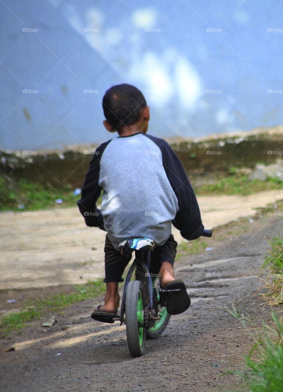 Little boy playing mini bike.