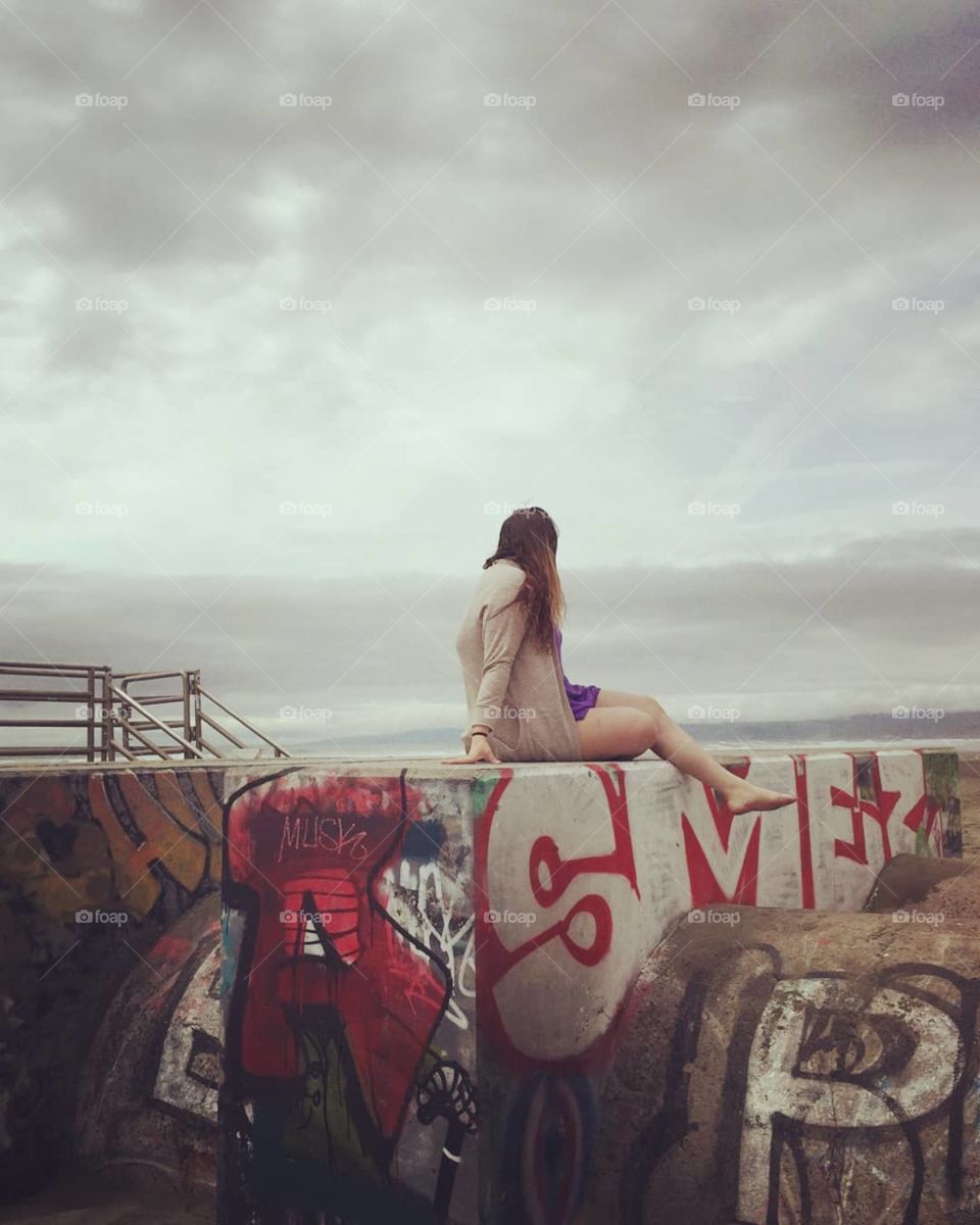 Posing on graffiti on a cloudy beach day in San Francisco