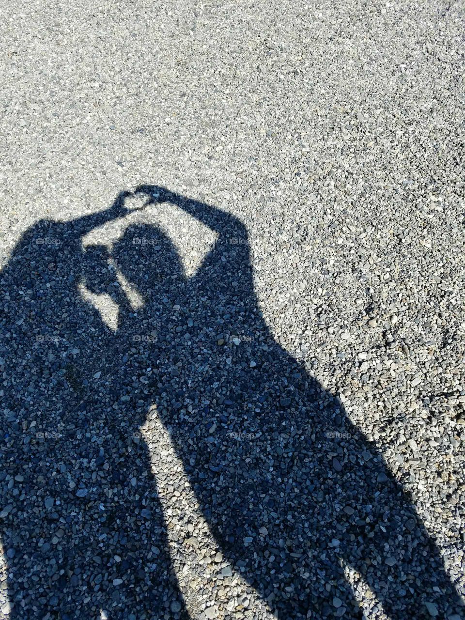 Shadow of two people making heart shape