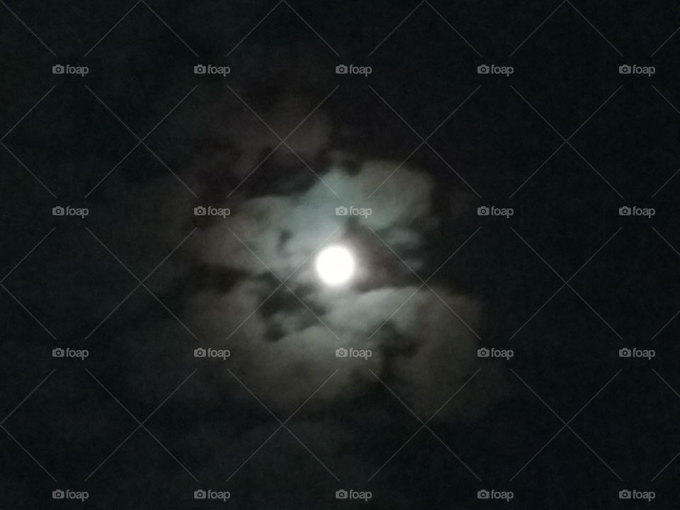Night Moon Brightening. Shining through the dark clouds.