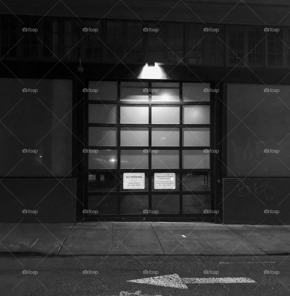 A windowed door on a seemingly abandoned block in the middle of the night.