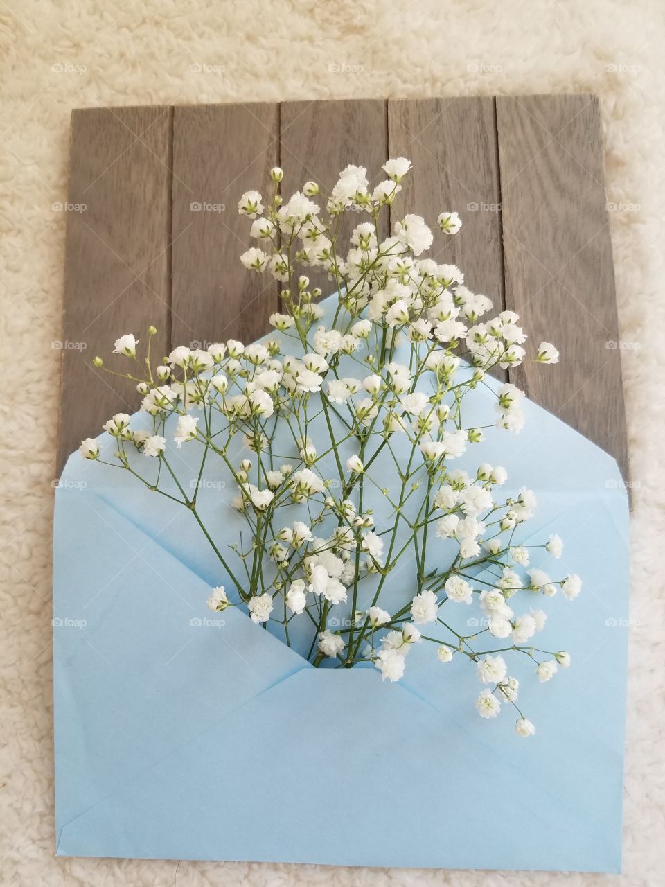 white babies breath bunch in a blue envelope with vintage theme