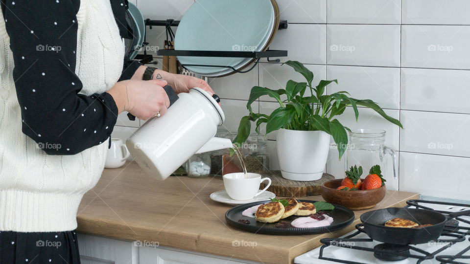 girl pouring tea into a mug