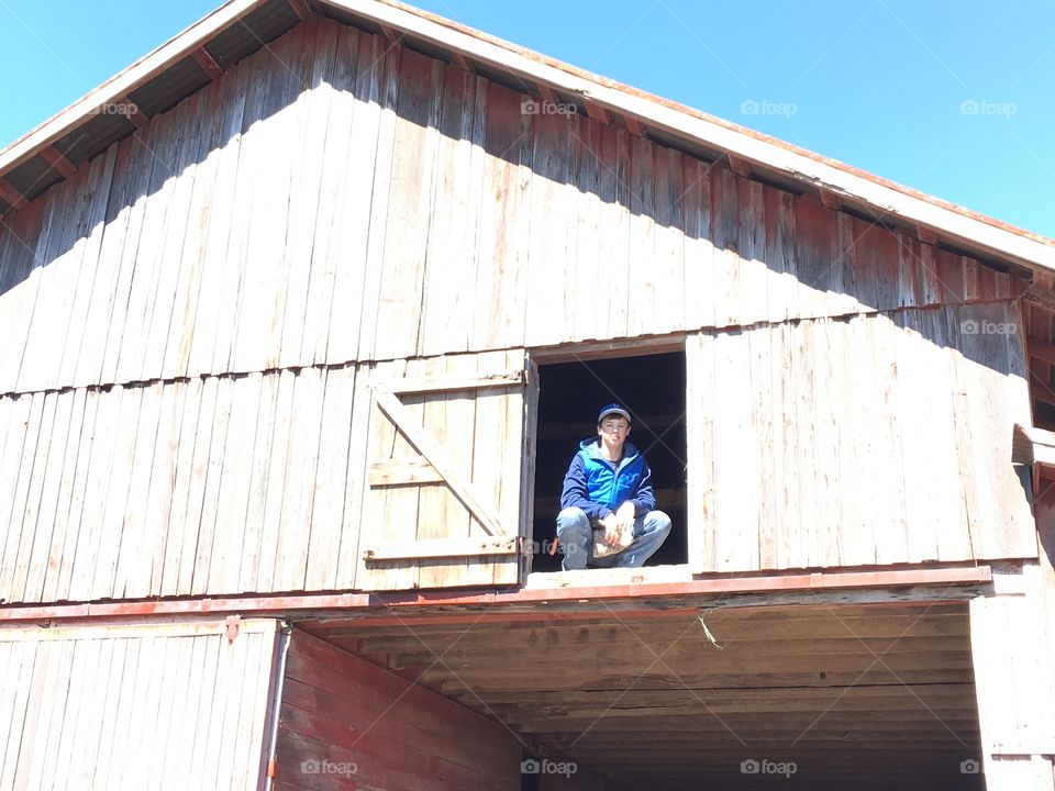 Low angle view of boy sitting near window