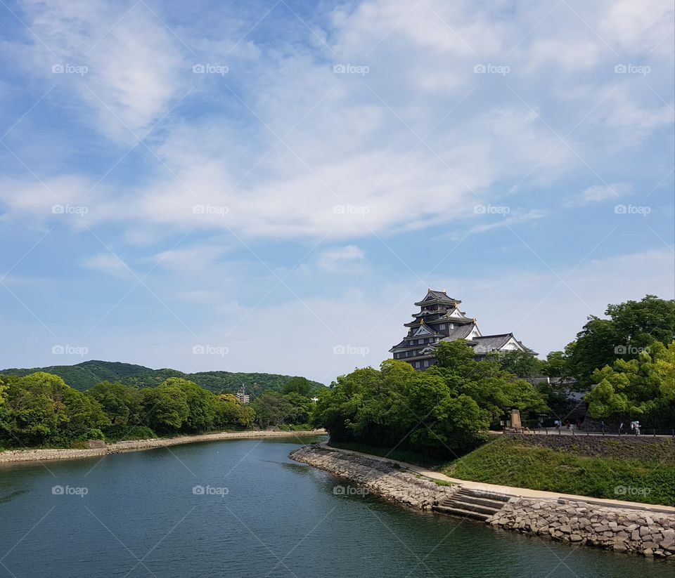 Okayama Castle with bright blue skys and deep blue water