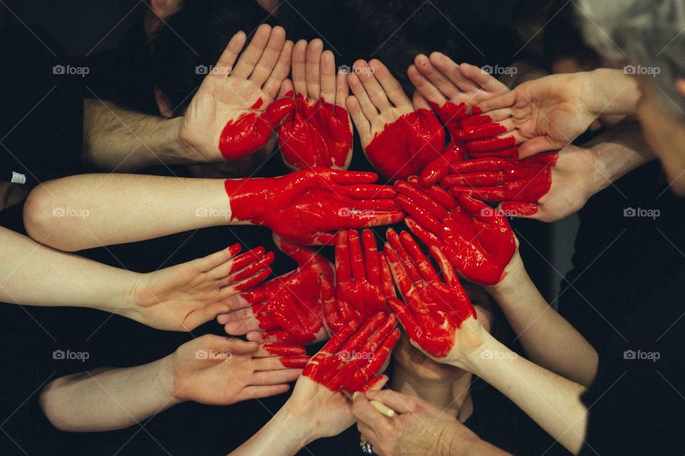 many people's hand are painted red to form together a large red heart