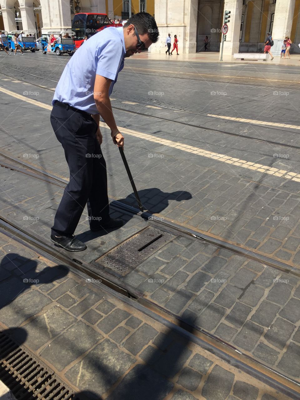 Man standing on street near manhole