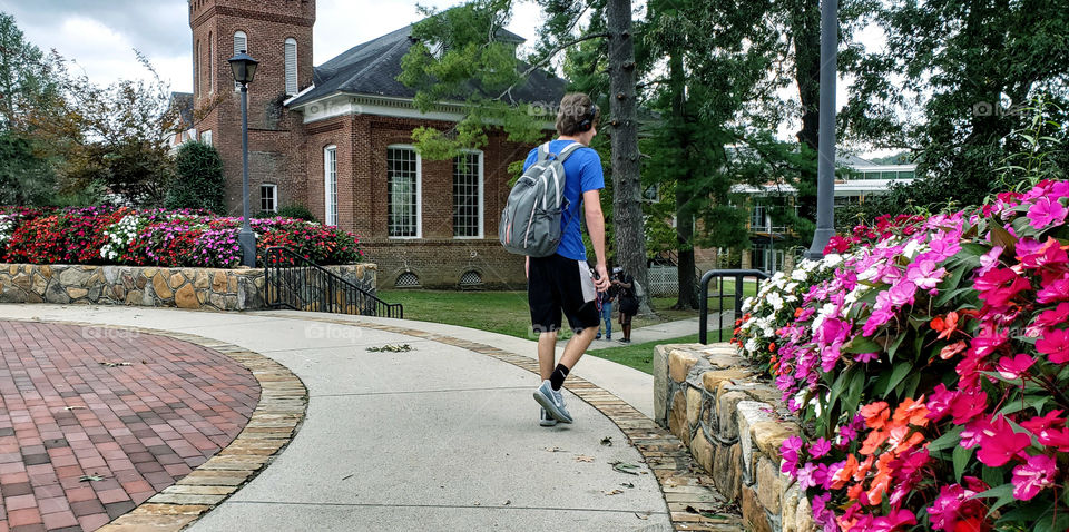 College student headed to class carrying books in his backpack...