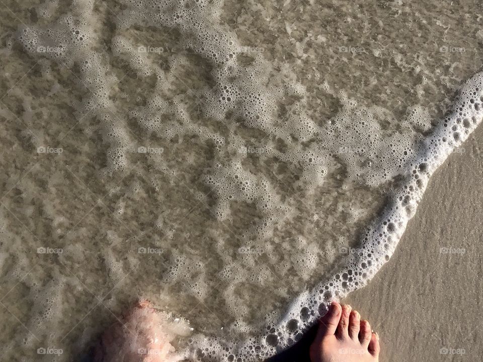 Toes in sand and water