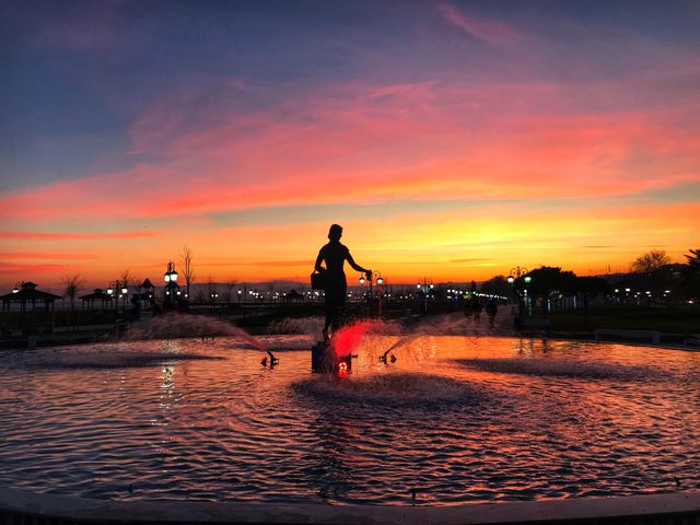 sunset with a woman statue