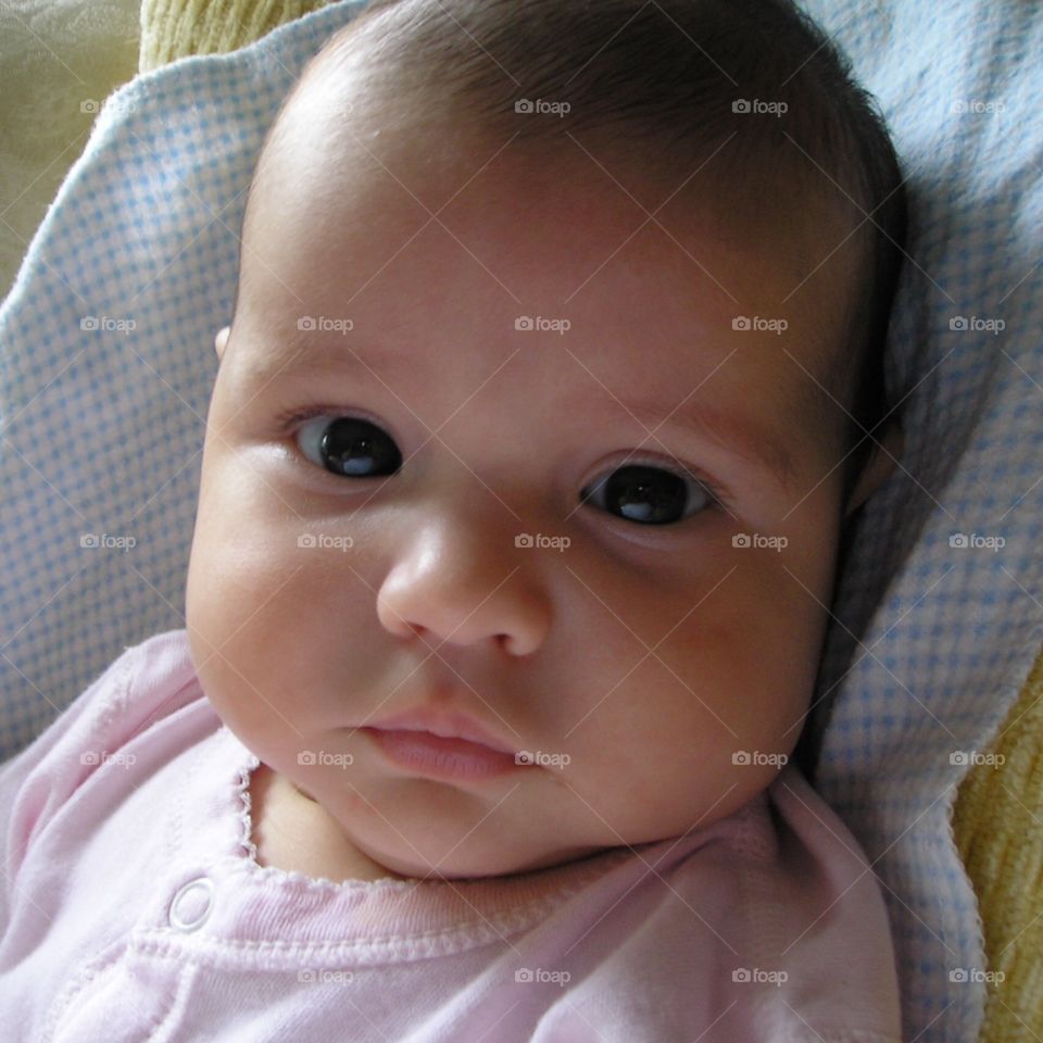 A closeup headshot of my first daughter with a face,not sad, but pensive and thoughtful; a kind of Mona Lisa smile. There is always a lot going on behind  those deep, dark, beautiful eyes. 