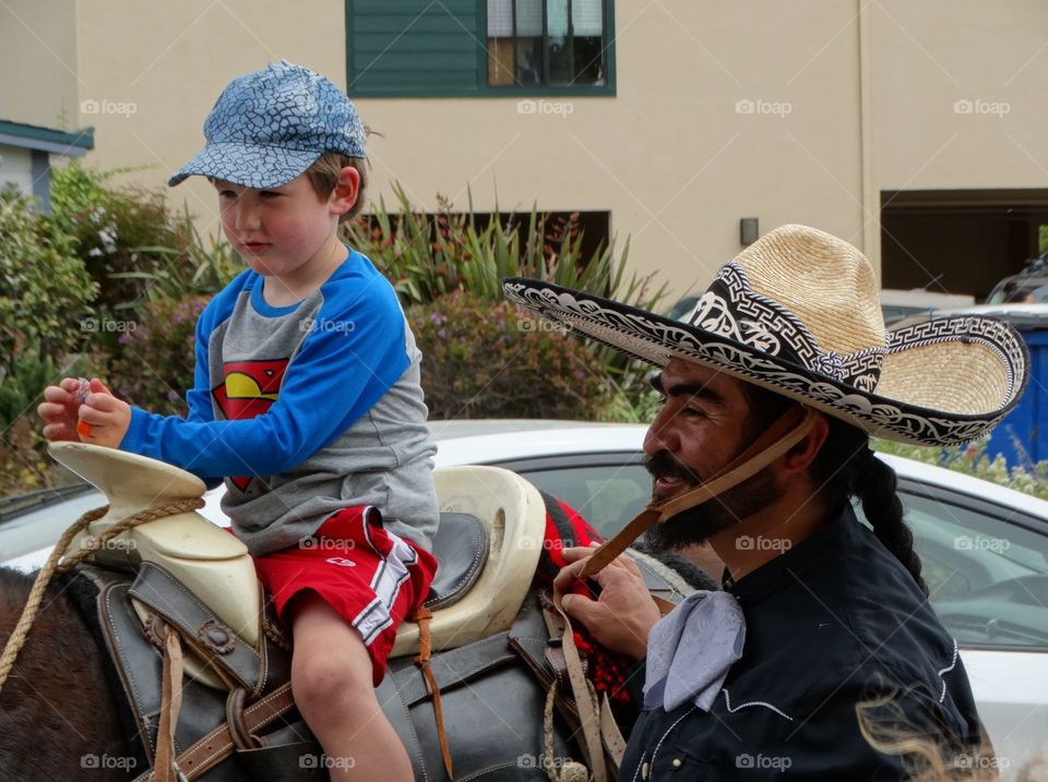 Young Boy On A Horse. Young Boy Learning To Ride From Mexican Cowboy
