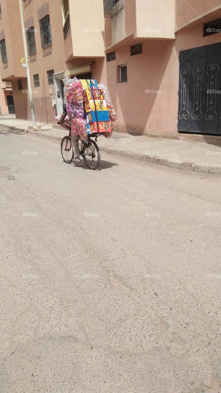 Bike rider carrying various sweets.