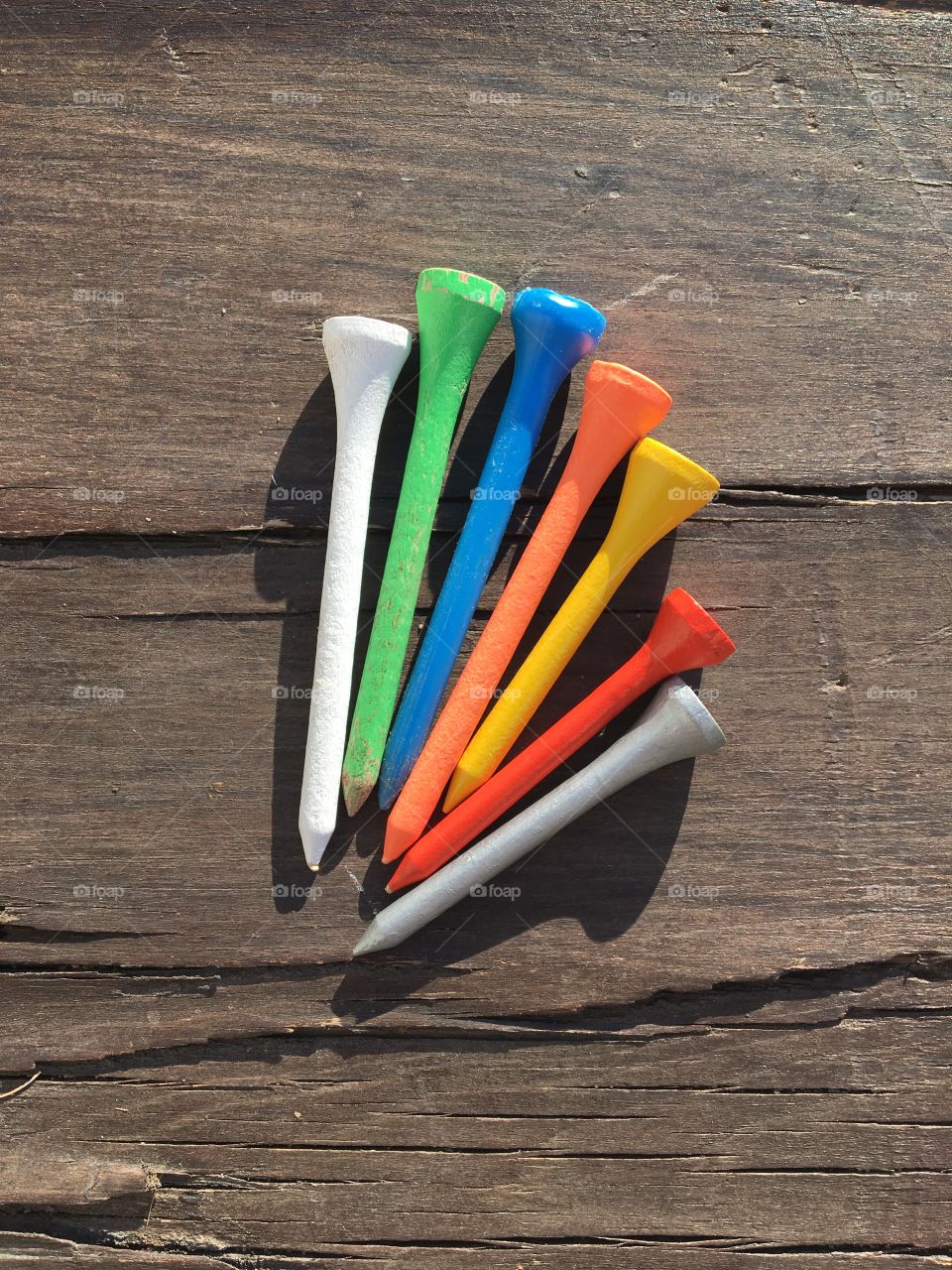 Flatlay of multicolore tees on wooden background 